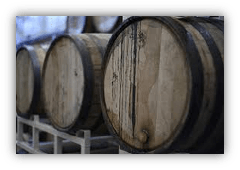 "Wooden barrels stacked in a winery, showcasing aging process."