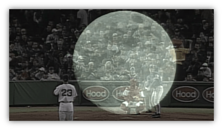 Baseball game scene with pitcher, batter, and crowd in the background.