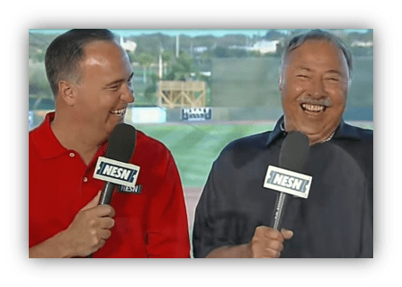 Two sports commentators laughing on set, wearing NESN shirts.