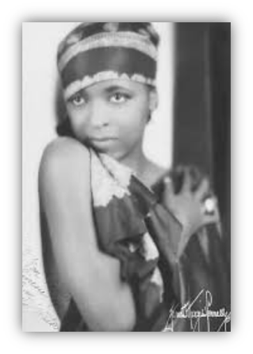Vintage black and white portrait of a young woman in a stylish outfit, showcasing 1920s fashion.