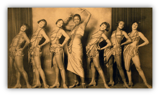 "Vintage photo of six women in 1920s performance attire, showcasing dance poses."