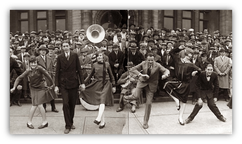 "1920s dance performance in front of a large crowd, showcasing lively choreography and vintage attire."