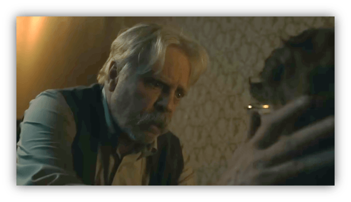 Elderly man interacting with a dog in a dimly lit room.