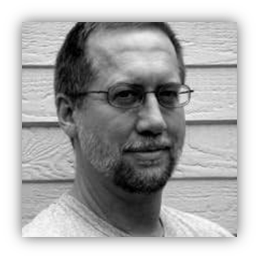 "Black and white portrait of a man with glasses and a beard."