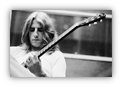 Musician playing guitar in a recording studio, black and white photo.