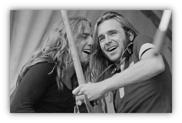 "Two musicians joyfully performing together on stage, showcasing camaraderie and passion for music."