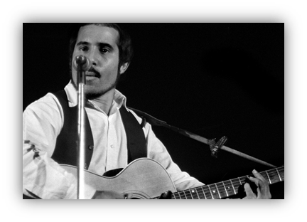 "Male musician performing with guitar and microphone on stage."
