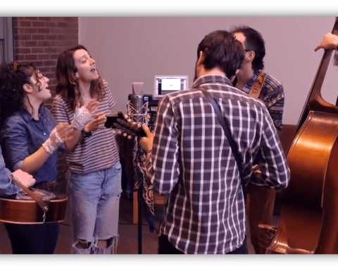 "Group of musicians performing in a studio, featuring guitars and a double bass."