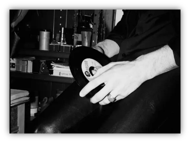 "Person holding a vinyl record, showcasing a vintage music vibe."