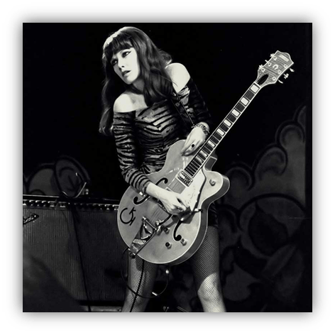 "Female guitarist performing on stage with a vintage Gretsch guitar."