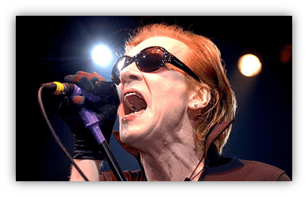 "Rock singer passionately performing on stage with sunglasses."