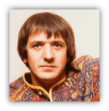 "Portrait of a man in a colorful patterned shirt with a serious expression."