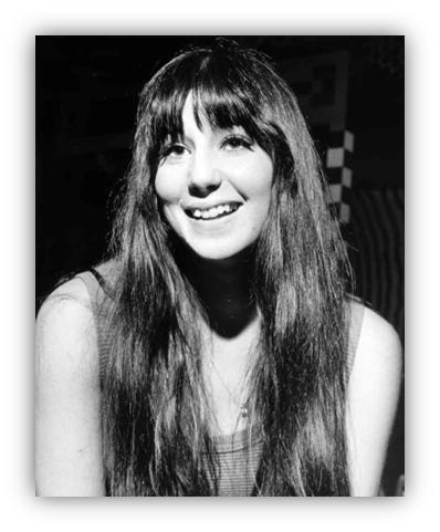 "Black and white portrait of a smiling young woman with long hair."