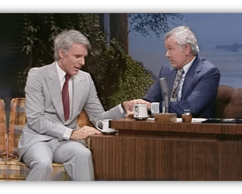 Steve Martin and Johnny Carson share a moment on The Tonight Show, seated at a talk show desk.