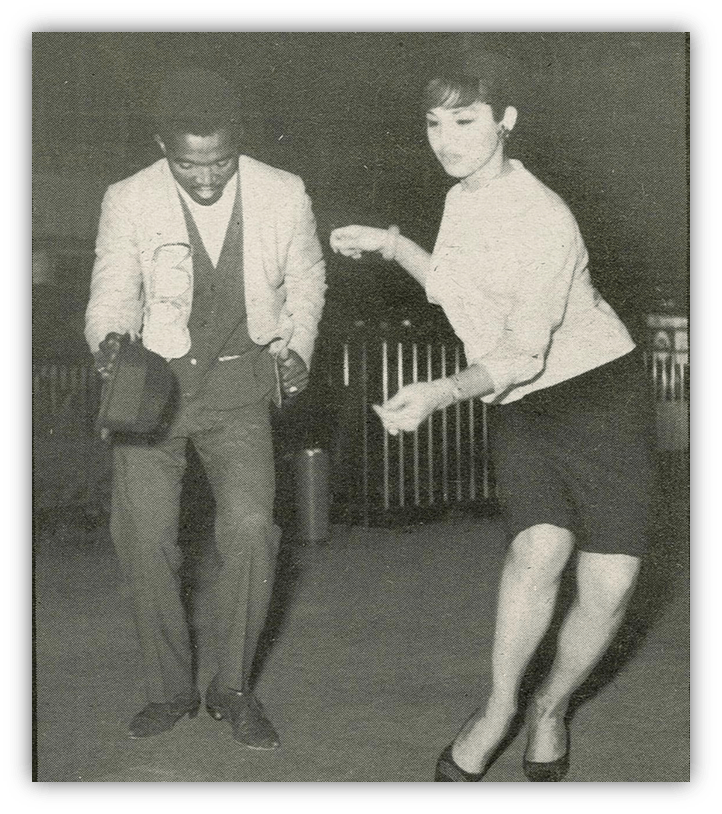 "Two dancers enjoying a lively dance in a vintage black-and-white setting."