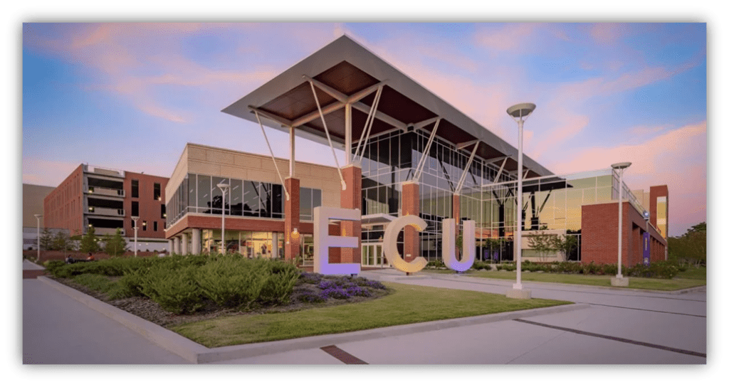 "ECU campus building with modern architecture and landscaped entrance at sunset."