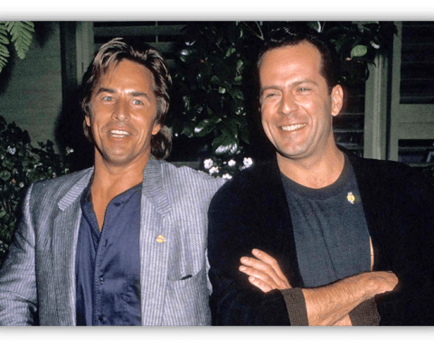 "Two smiling men in stylish outfits posing together outdoors."