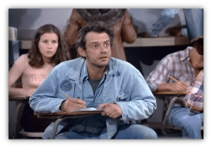 Student looking confused in a classroom setting, taking notes.