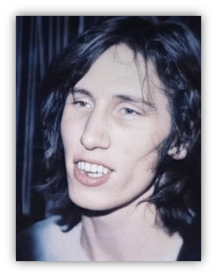 Young man with long hair smiling, captured in a vintage-style photo.