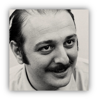 Black and white portrait of a smiling man with a mustache.