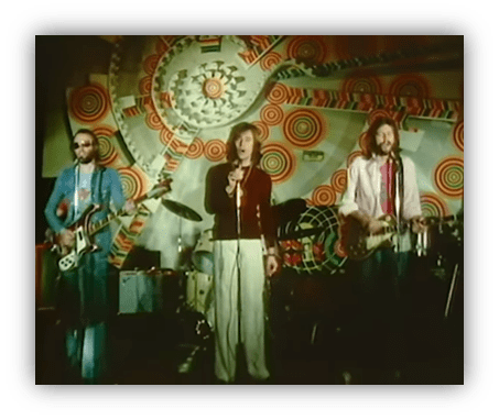 "1970s rock band performing on stage with vibrant psychedelic backdrop."