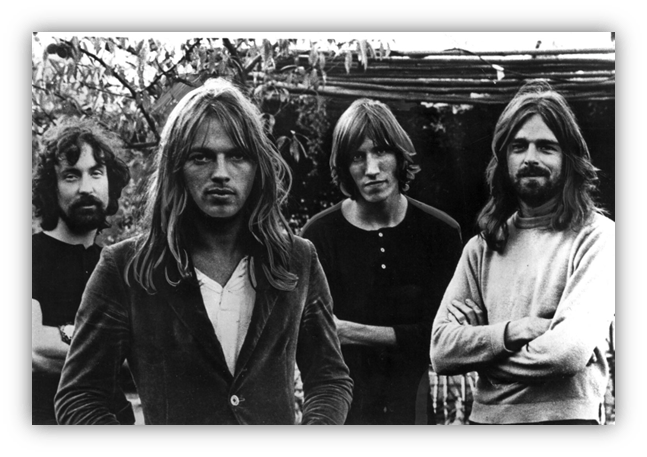 "Black and white photo of four male musicians with long hair, standing outdoors."