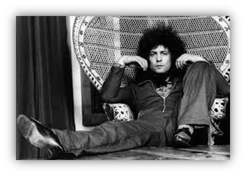 "Man with curly hair lounging in a vintage chair, black and white photo."