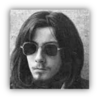 Black and white portrait of a young man with long hair and sunglasses.