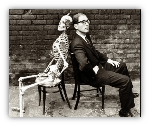 "Man and skeleton seated back-to-back in black and white photograph."