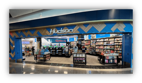 "Hudson retail store at airport with shelves of snacks and travel essentials."