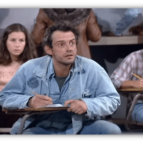 Student looking confused in a classroom setting, taking notes.