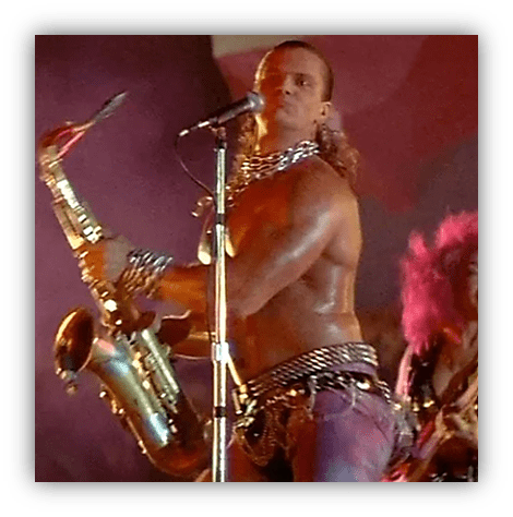 "Muscular musician playing saxophone on stage with vibrant lighting."