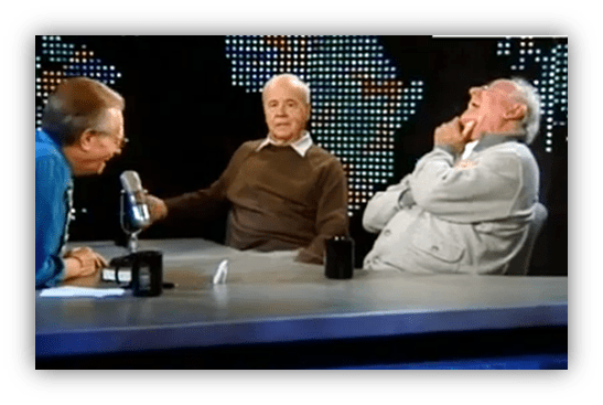 "Talk show hosts and guests laughing during an interview."