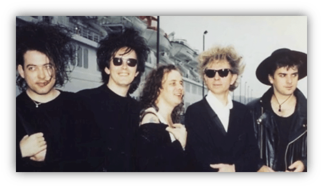 "Retro band photo featuring five members in stylish outfits and sunglasses."