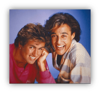 "Two young men smiling together, showcasing 1980s fashion and hairstyles."