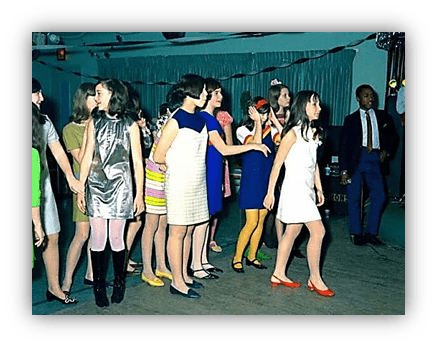 "Group of young girls in colorful 1960s dresses dancing at a party."