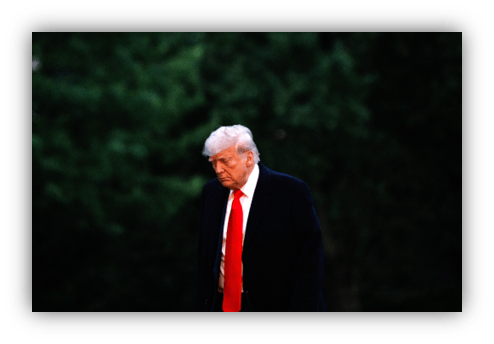 Former president walking outdoors in a dark suit and red tie.