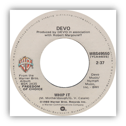 Alt text: "Vinyl record label for Devo's 'Whip It' from the album 'Freedom of Choice'."