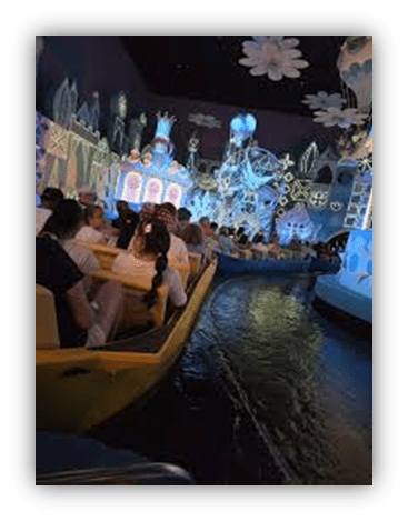 "Colorful boat ride through a whimsical, illuminated scene at an amusement park."