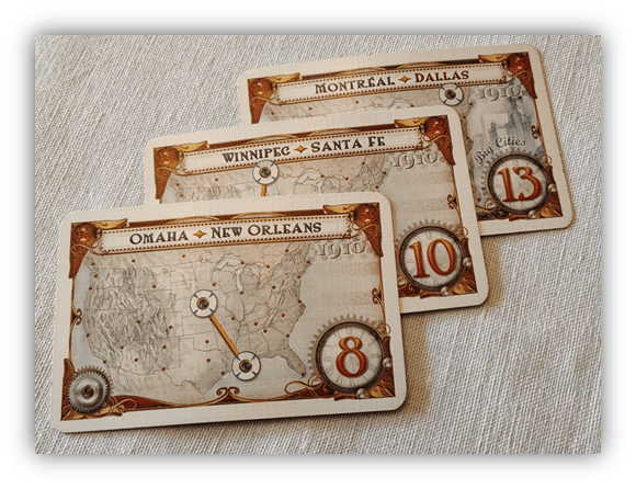 "Three vintage travel game cards featuring routes from Omaha to New Orleans, Winnipeg to Santa Fe, and Montreal to Dallas."
