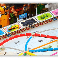 "Close-up of Ticket to Ride board game with colorful train pieces and destination cards."