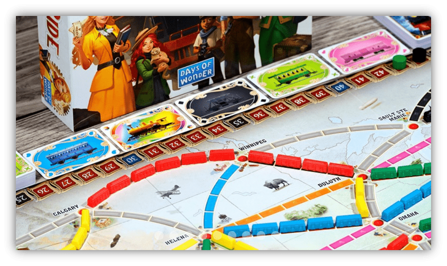 "Close-up of Ticket to Ride board game with colorful train pieces and destination cards."