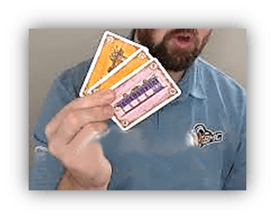 Person holding game cards in a blue shirt.