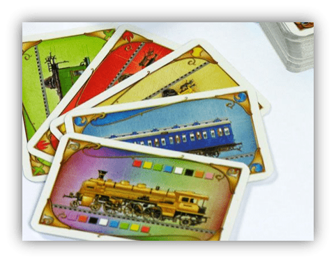 Colorful train-themed playing cards stacked on a table.