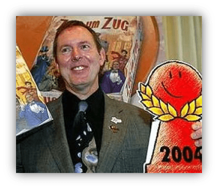 "Smiling man holding a board game and an award from 2004."