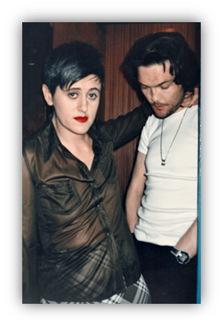 "Two stylish individuals posing together, showcasing bold fashion choices."