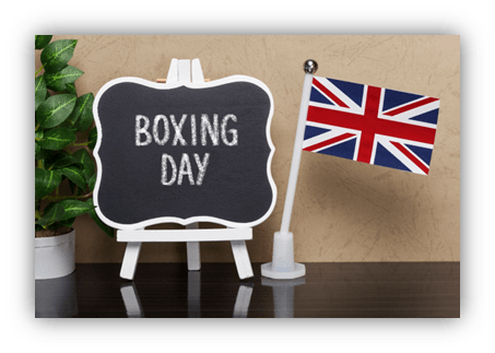 "Boxing Day sign with UK flag and decorative plant."