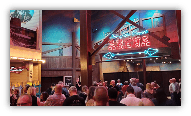 Crowd gathered at the Star of the Desert Arena with neon sign in a vibrant venue.