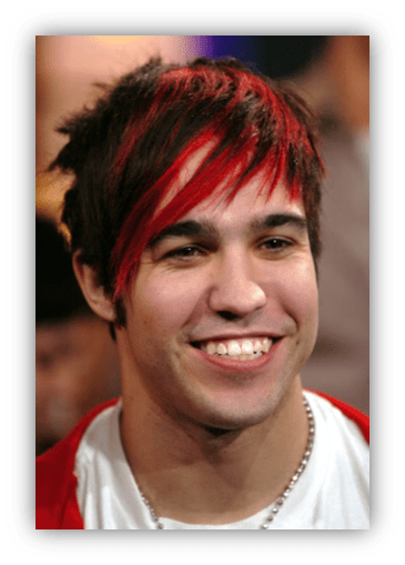 "Smiling young man with red and black hair, wearing a white shirt and red jacket."
