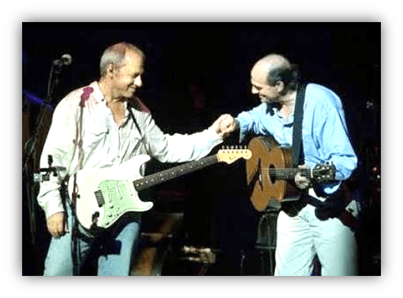 Musicians performing on stage, sharing a moment during a live concert.